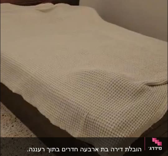 מיטה עם כיסוי בד בחדר שינה